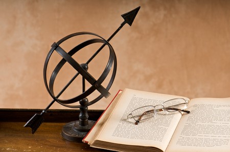 Old armillary with book and eyeglasses.