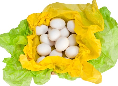 Natural basket with eggs and tissue paper in green and yellow.の写真素材