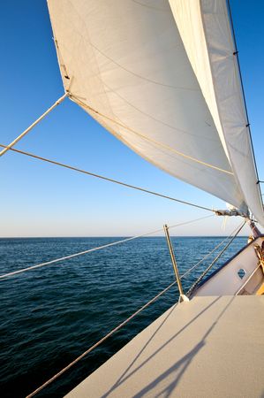 Sailboat navigating in the ocean at afternoon.
