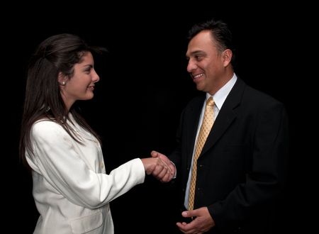Hispanic boss congratulates his secretary with a handshake.の写真素材