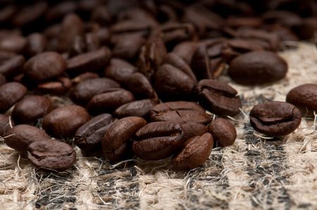 Macro shot of coffee beans over burlap.の写真素材