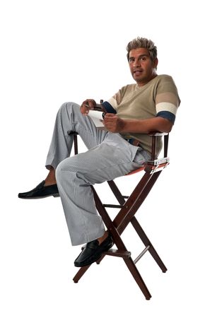 Young and trendy man seated on director chairs taking notes.の写真素材