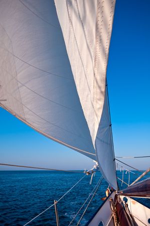 Sailboat navigates in the ocean at sunset time. Space for copy.の写真素材