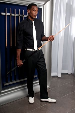 Young professional african american pool player posing with cue, in billiard saloon.の写真素材