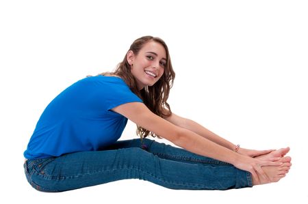 Young and happy caucasian woman, seated in the floor stretching.の写真素材