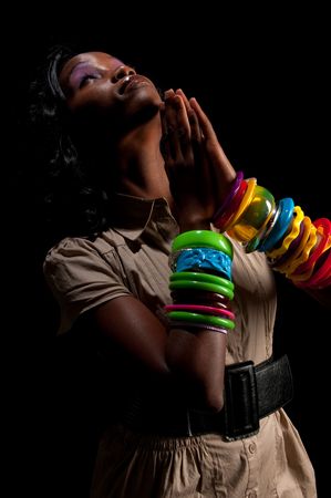Young african american praying in dim light.の写真素材