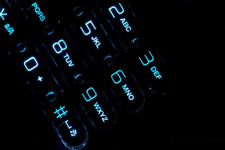 Close up view of a cell phone keypad backlit.