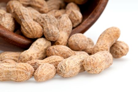 Close up view of peanuts spill from bowl, macro shot, use of selective focus.