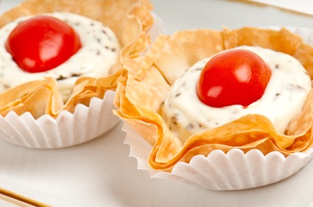 Volauvent canape of tomate and cheese, also called caprese. Volauvent is a tiny round canapé made of puff pastry. The term ' vol au vent ' means ' blown by the wind ' in French.の写真素材