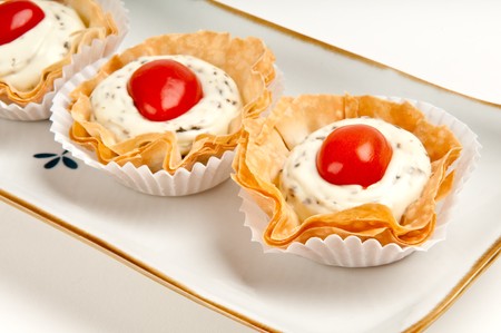 Volauvent canape of tomate and cheese, also called caprese. Volauvent is a tiny round canapé made of puff pastry. The term ' vol au vent ' means ' blown by the wind ' in French.の写真素材