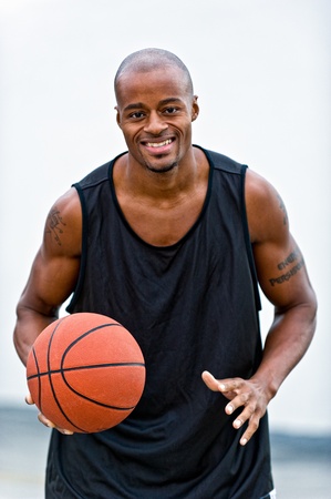 Young african american playing basketball in the street, smiling very happy.の写真素材
