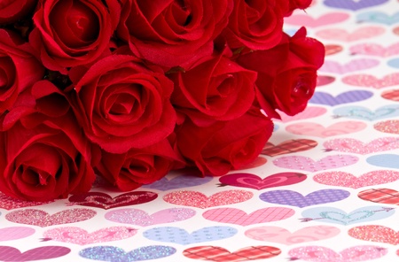 Artificial roses, over background of hearts, space for copy.の写真素材