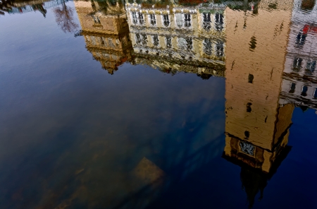 Historic buildings in Prague reflecting over the Vltava river.の写真素材