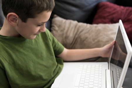 6 year boy hapy playing with computer at homeの写真素材