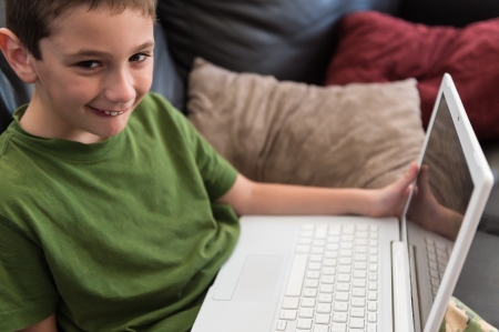 6 year boy hapy playing with computer at homeの写真素材