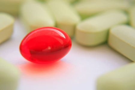 Red tablet among tablets of green colourの写真素材