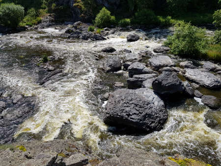 Large stone boulders lie in a mountain river
