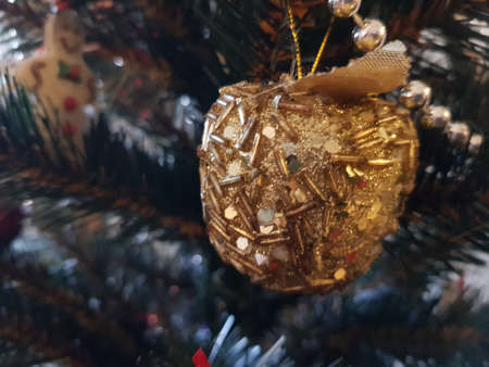 Golden Christmas toy on a branch of a Christmas treeの写真素材