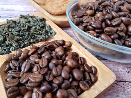 Brown coffee beans lie in a plateの写真素材