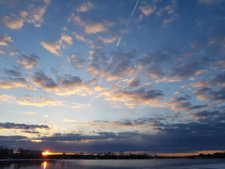 The plane flies leaving a trail in the blue skyの写真素材