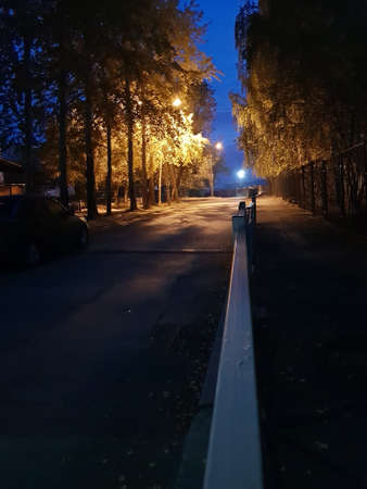 Yellow lanterns shine on the street in the eveningの写真素材