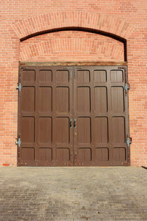 Antique wooden door in a stone wallの写真素材