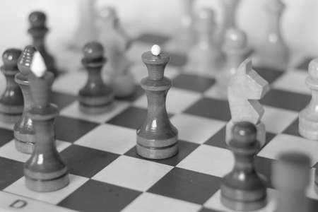 Figure of a black chess queen on a chessboard