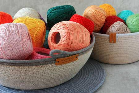 Multi-colored balls of thread in a basketの写真素材