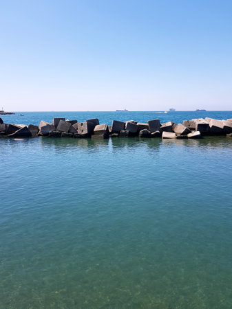 concrete breakwater in the sea, blue sky background, nature seriesの写真素材