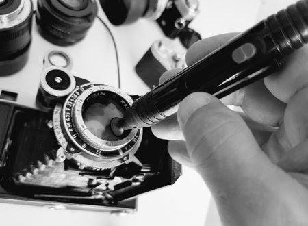 Close-up of a man's hand holding a camera lens.の写真素材