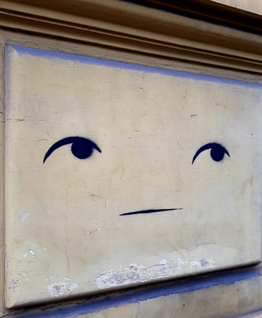 Drawing on the wall of an old building with a sad faceの写真素材