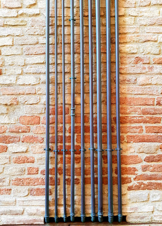 Pipes on a brick wall in the old town