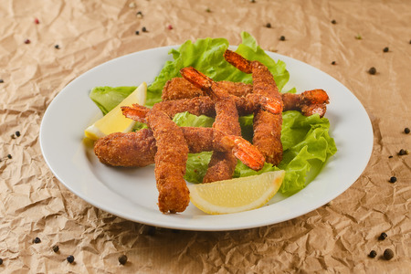 fried shrimps with lemon on plateの写真素材
