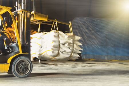 Forklift carries jumbo bag of refine white sugar to put on the stack inside warehouse. Sugar warehouse operations and management.の写真素材