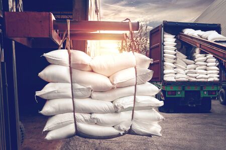 Forklift handling white sugar bag from warehouse for stuffing into container for export, vintage color.の写真素材