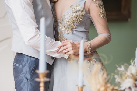 one young slim bride dressing in lace wedding dress preparing for ceremonyの写真素材