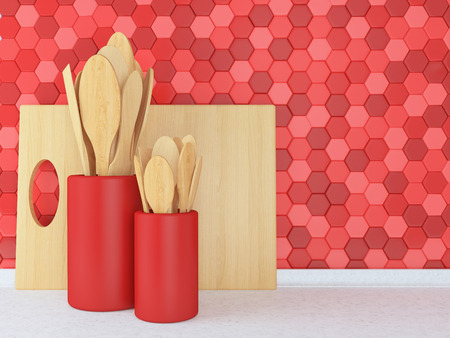 Wooden utensils on the white worktop in front of red tile wall.の写真素材