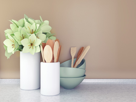 Wooden utensils and flowers on the white marble worktop in front of brown wall.の写真素材