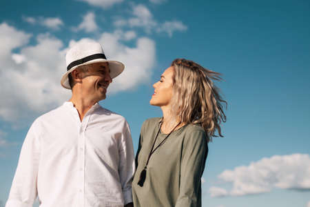Woman and man walk on the beach in sunny weather