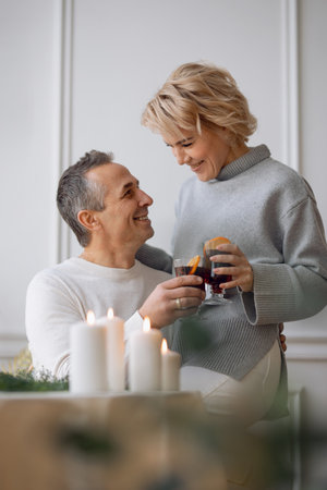 adult man and woman drink mulled wine at the festive tableの写真素材