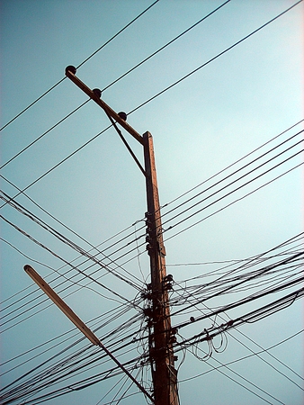 Chaotic wire on electric posts and blue sky backgroundの写真素材