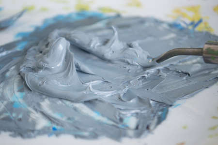 A photo with an image of gray oil paint on the palette. Close-up.