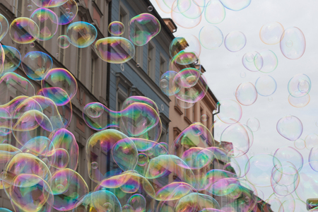 Soap bubbles on the background of colorful ancient buildings and gray skyの写真素材