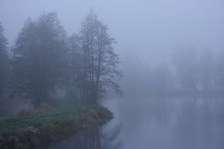 Road by the lake in the mistの写真素材