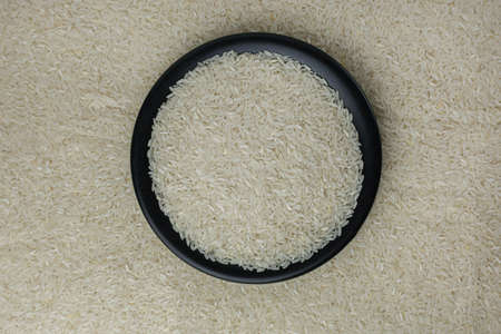 White rice on a black plate in the background around the strewn riceの写真素材