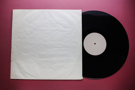 Classic vinyl record with packaging closeup on a red burgundy background, outdated data storage, musicの写真素材