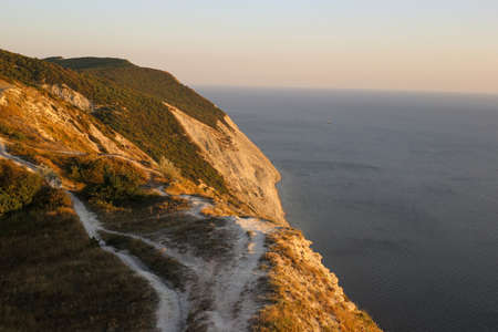 Rocky mountains with landscape island vegetation for tourists along the sea at sunset overlooking the horizonの写真素材