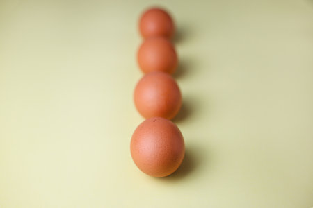 Brown eggs on a light yellow isolated backgroundの写真素材