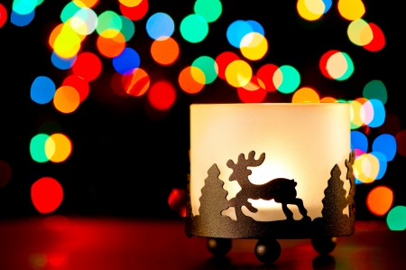 Candlestick with a figure of a deer on the background of blurred lights garlands.の写真素材
