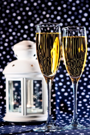 Two glasses of champagne and a white lantern on a star backgroundの写真素材